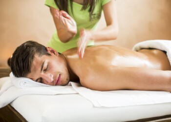 Young man having massage in spa Back Massage